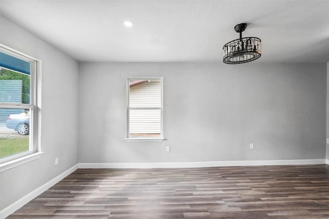 7000 Carwill Dr, Austin, TX 78724 - unfurnished room with plenty of natural light, wood finished floors, a chandelier, baseboards, and recessed lighting