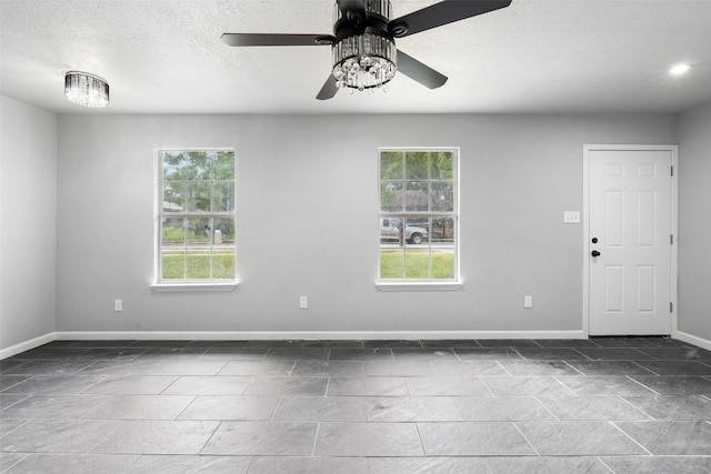 7000 Carwill Dr, Austin, TX 78724 - unfurnished room with baseboards, a ceiling fan, and a textured ceiling