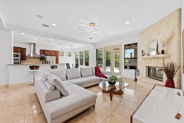 living area with recessed lighting, a premium fireplace, baseboards, light tile patterned floors, and a chandelier