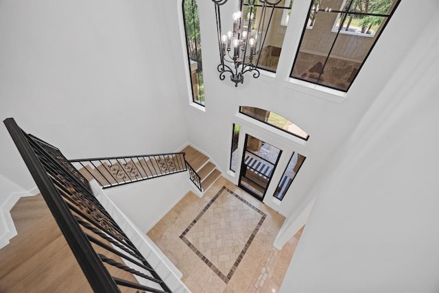 entrance foyer with inlaid floor details, a chandelier, plenty of natural light, and baseboards