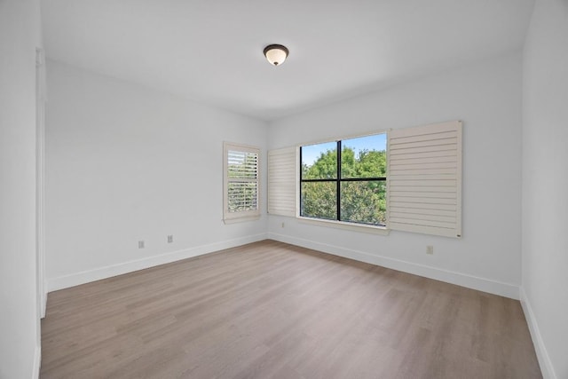 empty room with wood finished floors and baseboards