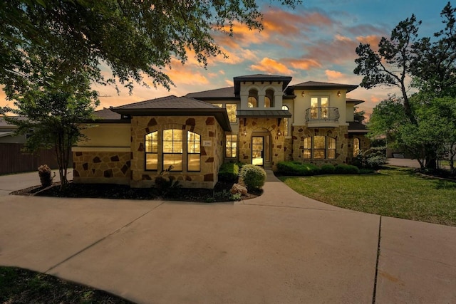 206 Lido St, Austin, TX 78734 - mediterranean / spanish-style home featuring stone siding, a balcony, a lawn, driveway, and stucco siding
