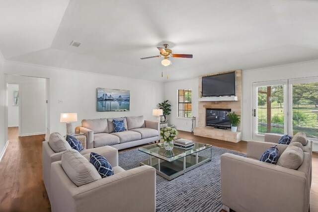 507 Canyon Wren Dr, Buda, TX 78610 - living room with wood finished floors, a ceiling fan, a large fireplace, ornamental molding, and baseboards
