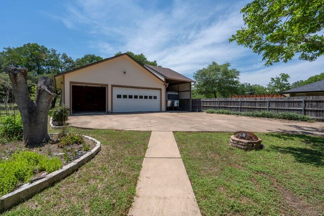 507 Canyon Wren Dr, Buda, TX 78610 - view of front of house with a fire pit, stucco siding, a garage, and concrete driveway