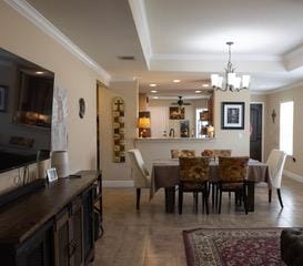 834 Salado Creek Ln, Georgetown, TX 78633 - dining space with a tray ceiling, crown molding, a chandelier, baseboards, and a ceiling fan