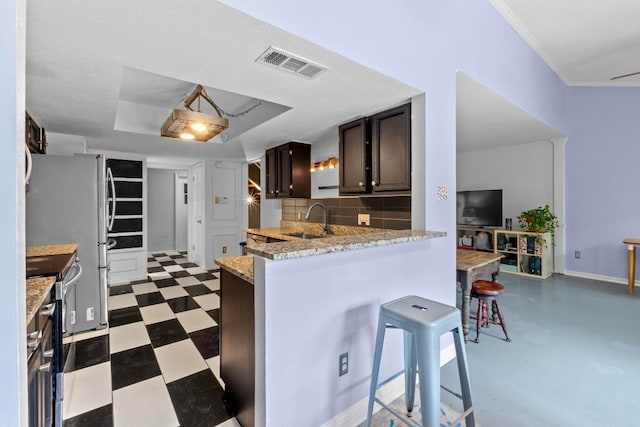 1605 Coronado Hills Dr Unit B, Austin, TX 78752 - kitchen featuring a sink, stainless steel appliances, a kitchen breakfast bar, dark brown cabinetry, and a peninsula