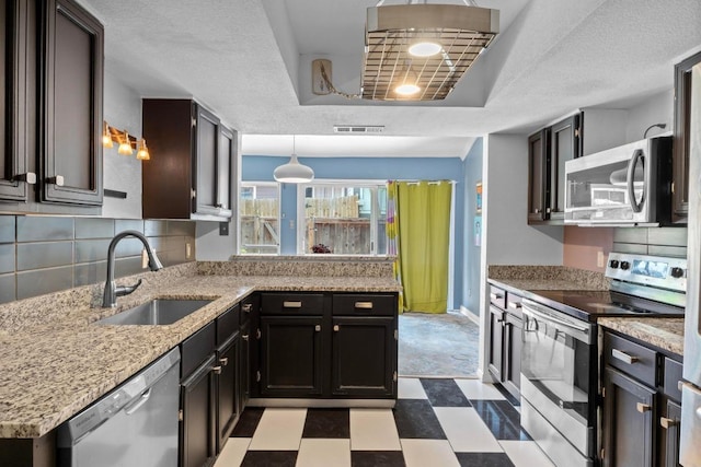 1605 Coronado Hills Dr Unit B, Austin, TX 78752 - kitchen with stainless steel appliances, a sink, a tray ceiling, backsplash, and tile patterned floors