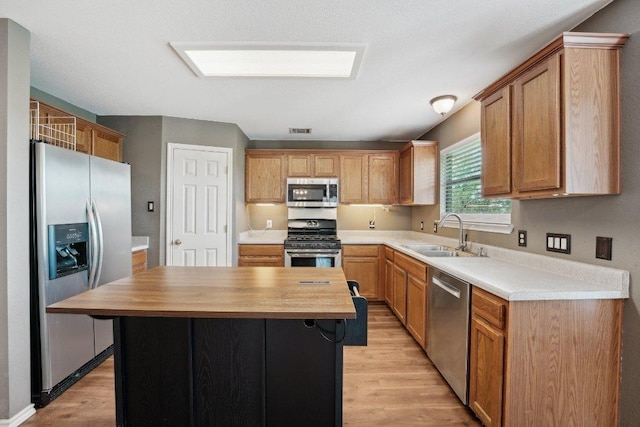 14104 Ballycastle Trl, Austin, TX 78717 - kitchen with appliances with stainless steel finishes, light wood finished floors, butcher block countertops, and a kitchen island