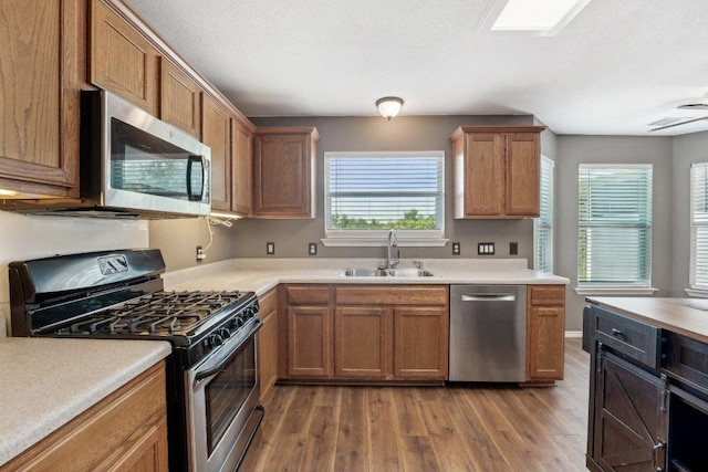 14104 Ballycastle Trl, Austin, TX 78717 - kitchen featuring appliances with stainless steel finishes, wood finished floors, light countertops, and brown cabinets