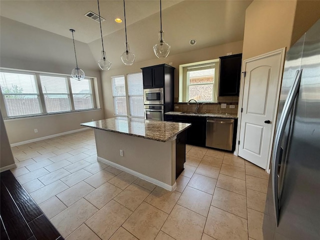 17300 Gabbro Dr, Pflugerville, TX 78660 - kitchen with stainless steel appliances, vaulted ceiling, light tile patterned floors, light stone countertops, and a center island