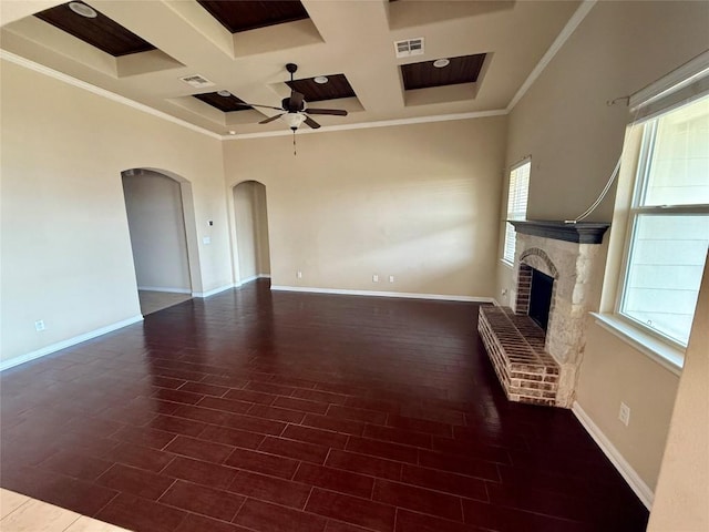 unfurnished living room featuring coffered ceiling, ceiling fan, arched walkways, healthy amount of natural light, and baseboards