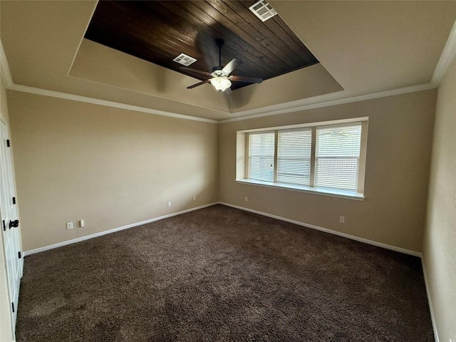 17300 Gabbro Dr, Pflugerville, TX 78660 - empty room featuring a raised ceiling, baseboards, dark carpet, ceiling fan, and crown molding