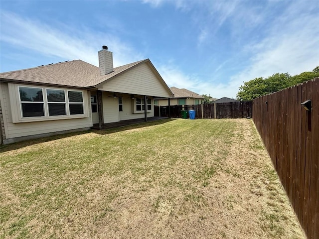back of property featuring a ceiling fan, a chimney, and a shingled roof