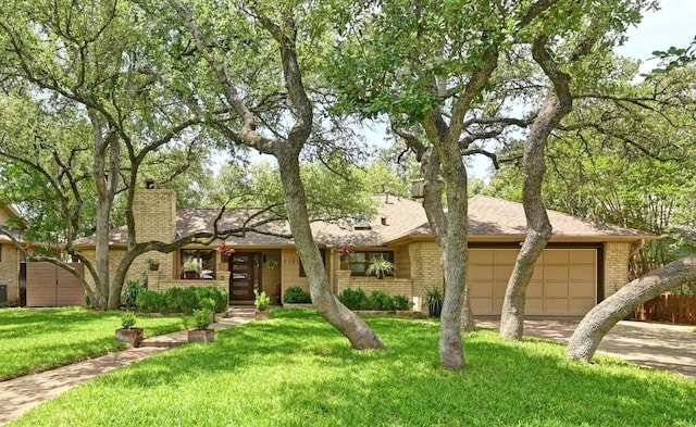 7303 Carlwood Dr, Austin, TX 78759 - view of front of house with an attached garage, a chimney, brick siding, a front yard, and concrete driveway