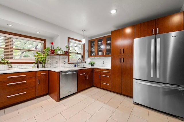 7303 Carlwood Dr, Austin, TX 78759 - kitchen featuring stainless steel appliances, a sink, light countertops, decorative backsplash, and glass insert cabinets