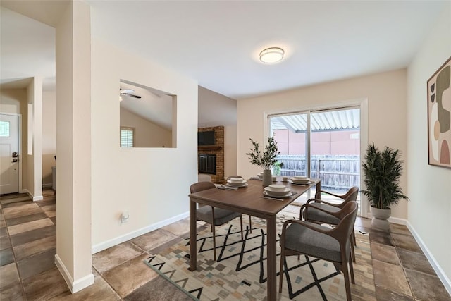 7815 Croftwood Dr, Austin, TX 78749 - dining area featuring baseboards, vaulted ceiling, and a brick fireplace