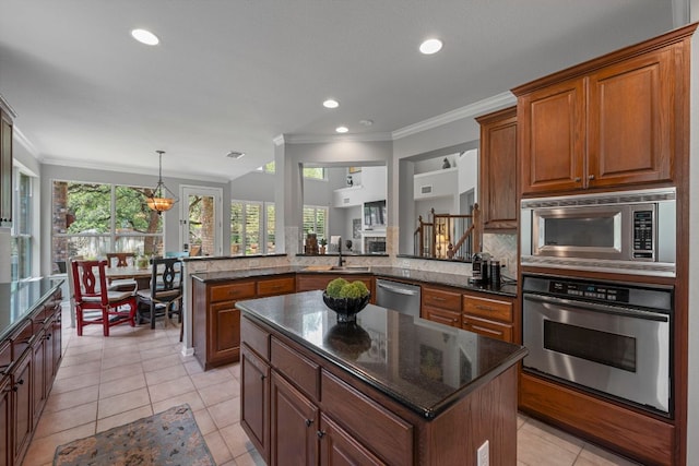 kitchen with stainless steel appliances, crown molding, a sink, a peninsula, and light tile patterned floors