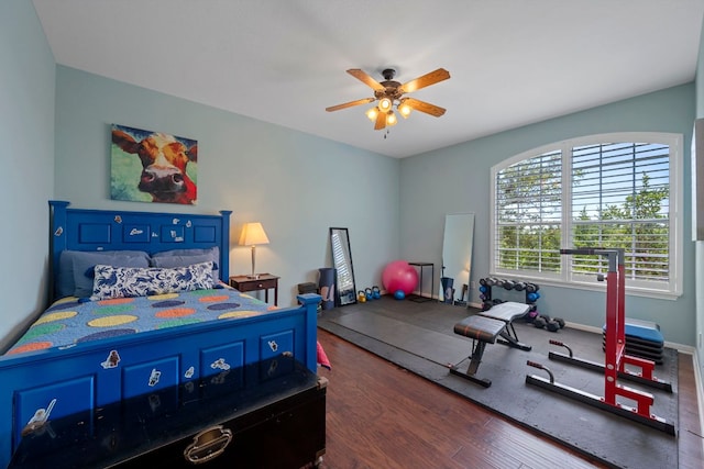 bedroom featuring wood finished floors, a ceiling fan, and baseboards