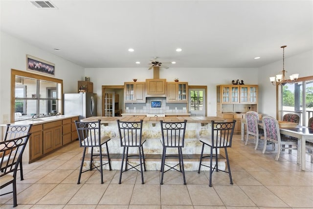 14415 Evergreen Cv, Austin, TX 78737 - kitchen with a chandelier, recessed lighting, light countertops, a breakfast bar area, and light tile patterned floors