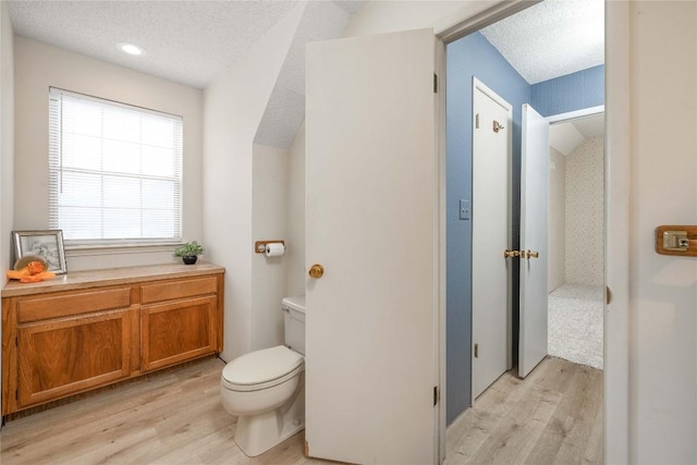 28920 Country Dr, New Braunfels, TX 78132 - bathroom with wood finished floors, toilet, and a textured ceiling