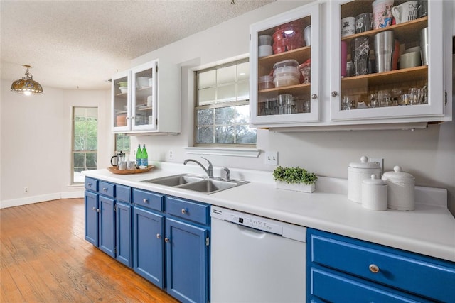 28920 Country Dr, New Braunfels, TX 78132 - kitchen with white dishwasher, blue cabinets, a sink, light countertops, and a textured ceiling