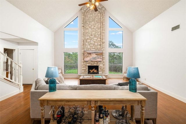 28920 Country Dr, New Braunfels, TX 78132 - living area with high vaulted ceiling, ceiling fan, plenty of natural light, a stone fireplace, and wood finished floors