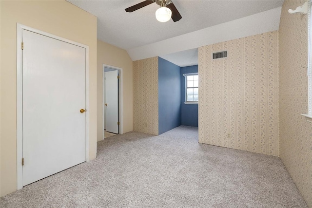 28920 Country Dr, New Braunfels, TX 78132 - unfurnished bedroom with carpet floors, wallpapered walls, lofted ceiling, and ceiling fan