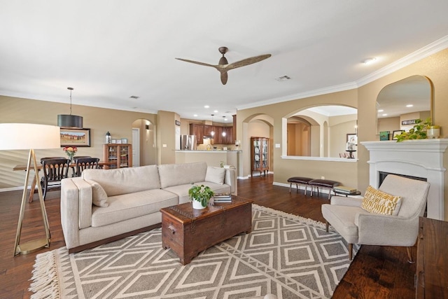 313 Monahans Dr, Georgetown, TX 78628 - living area featuring wood finished floors, ceiling fan, crown molding, arched walkways, and recessed lighting