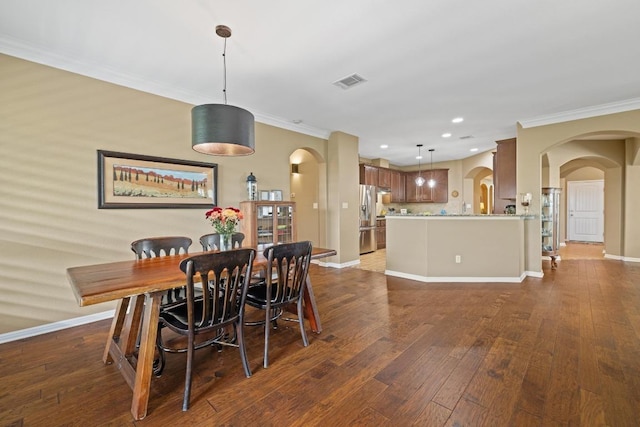 313 Monahans Dr, Georgetown, TX 78628 - dining area featuring arched walkways, ornamental molding, hardwood / wood-style floors, recessed lighting, and baseboards