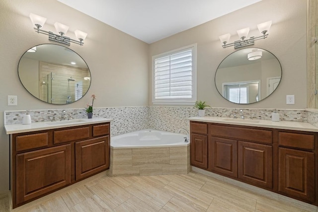 313 Monahans Dr, Georgetown, TX 78628 - bathroom featuring a bath, two vanities, a shower stall, and tile patterned floors
