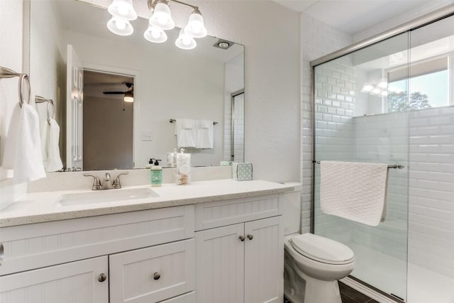 full bath with a shower stall, toilet, vanity, ceiling fan, and a chandelier