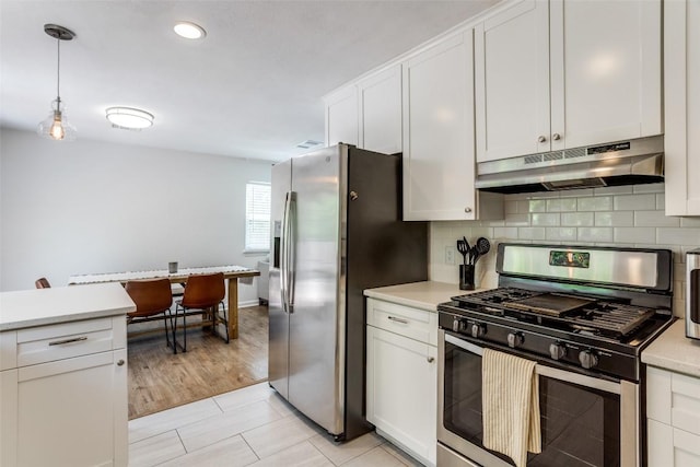 809 Meadowcreek Dr, Round Rock, TX 78664 - kitchen featuring stainless steel appliances, under cabinet range hood, light countertops, white cabinetry, and backsplash