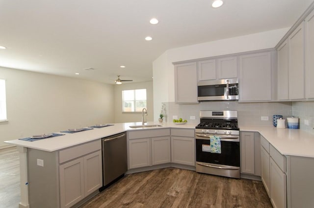 217 Deserti Rd, Leander, TX 78641 - kitchen featuring appliances with stainless steel finishes, a sink, gray cabinets, a peninsula, and recessed lighting