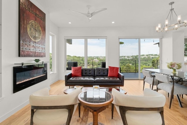 5728 Misty Hill Cv, Austin, TX 78759 - living room featuring light wood-style floors, recessed lighting, baseboards, a glass covered fireplace, and a ceiling fan