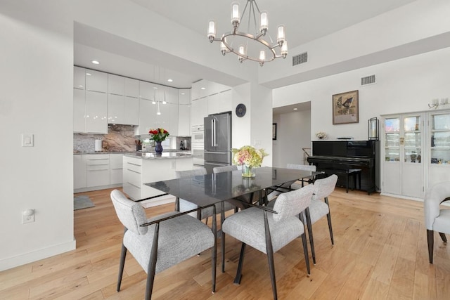 5728 Misty Hill Cv, Austin, TX 78759 - dining room with a chandelier, light wood-style floors, baseboards, and a high ceiling
