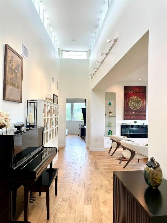 5728 Misty Hill Cv, Austin, TX 78759 - hallway with a towering ceiling, light wood finished floors, and baseboards