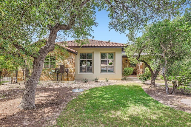 back of property featuring a tiled roof and stucco siding