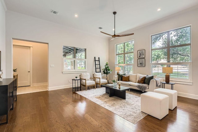 living room featuring baseboards, a ceiling fan, dark wood-type flooring, recessed lighting, and crown molding