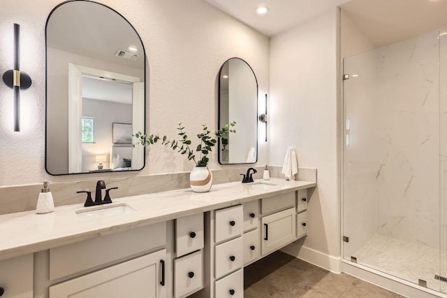 full bath with a marble finish shower, double vanity, tile patterned flooring, and recessed lighting