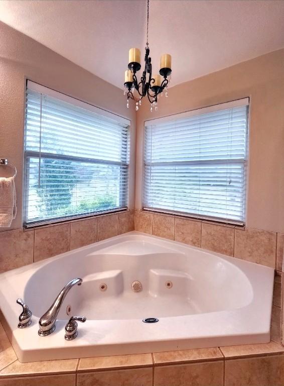 149 Mcallister Rd, Bastrop, TX 78602 - bathroom with a whirlpool tub and a chandelier