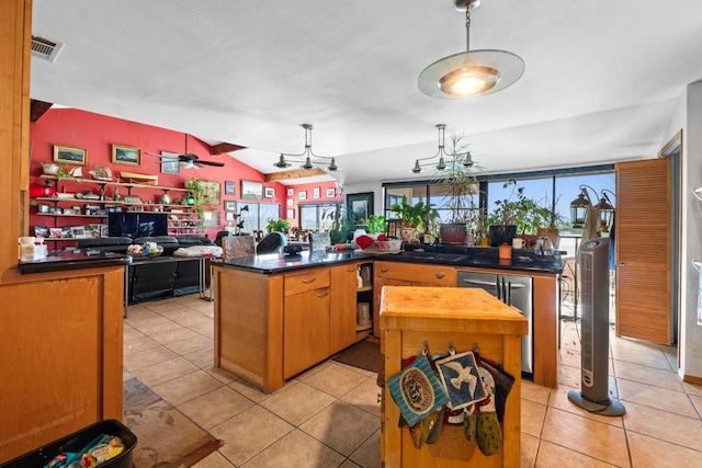 909 Redbud Trl, West Lake Hills, TX 78746 - kitchen featuring light tile patterned floors, dark countertops, lofted ceiling, and a kitchen island