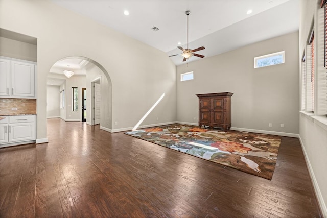 2761 Fishing Hole Cv, Leander, TX 78641 - unfurnished living room featuring arched walkways, a ceiling fan, plenty of natural light, dark wood finished floors, and high vaulted ceiling