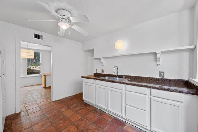 713 Patterson Ave, Austin, TX 78703 - kitchen featuring a sink, dark countertops, ceiling fan, and white cabinets