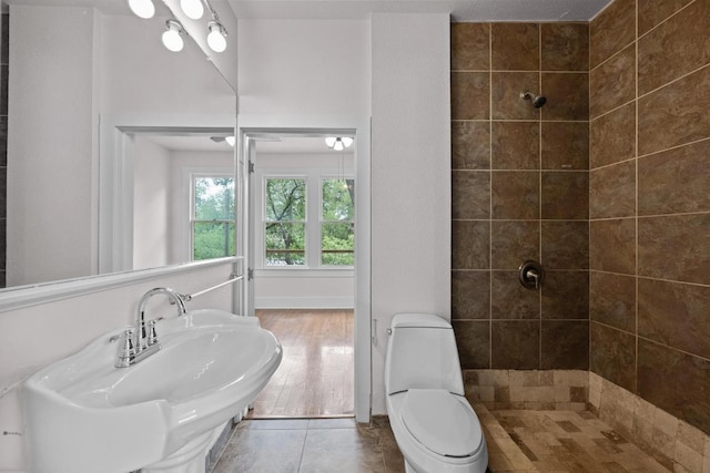 713 Patterson Ave, Austin, TX 78703 - bathroom featuring tiled shower, tile patterned flooring, and toilet