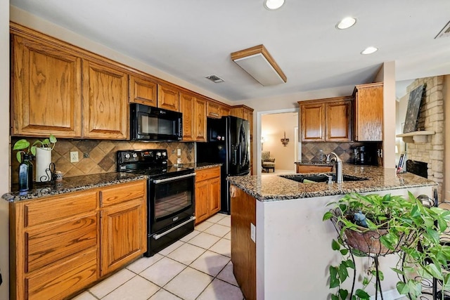 217 Fox Xing, Burnet, TX 78611 - kitchen featuring black appliances, a sink, decorative backsplash, dark stone countertops, and a peninsula