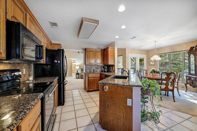 217 Fox Xing, Burnet, TX 78611 - kitchen with black appliances, a sink, a peninsula, brown cabinets, and light tile patterned floors
