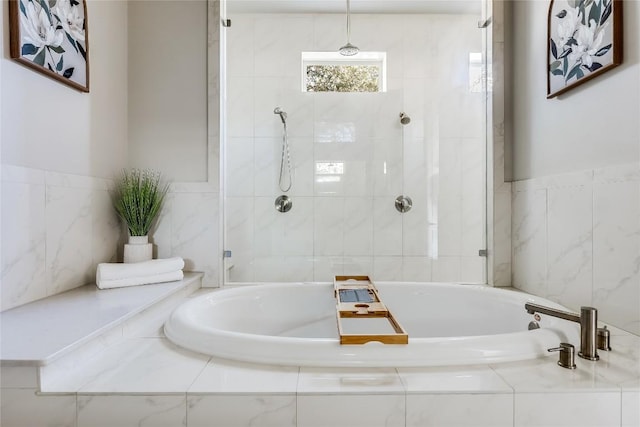 bathroom featuring a bath, tiled shower, tile walls, and a wainscoted wall