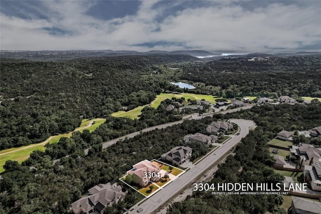 aerial view of residential area featuring a local golf course, a water and mountain view, property boundaries highlighted, and a forest