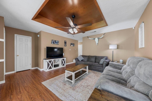 1611 Velma Ave, Copperas Cove, TX 76522 - living room with a raised ceiling, dark wood-style flooring, ceiling fan, and baseboards