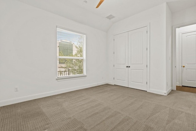 unfurnished bedroom with carpet floors, vaulted ceiling, baseboards, a closet, and ceiling fan